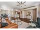 Open-concept living room with hardwood floors, ceiling fan, and seamless flow to kitchen and dining areas at 10115 Ringling St, New Port Richey, FL 34655