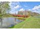 Scenic pond view with a red wooden walking bridge extending over the water at 10115 Ringling St, New Port Richey, FL 34655