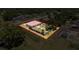 Aerial view of fenced property with fire pit and adjacent screened-in pool enclosure at 10124 Heathcliff St, Spring Hill, FL 34608