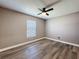Empty bedroom features a ceiling fan, hardwood floors, a neutral color palette, and a window at 10124 Heathcliff St, Spring Hill, FL 34608