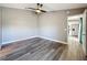 Neutral bedroom featuring hardwood floors, a ceiling fan, and an open doorway to the kitchen at 10124 Heathcliff St, Spring Hill, FL 34608