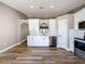 Modern kitchen featuring white cabinets, stainless steel appliances, and wood-look floors at 10124 Heathcliff St, Spring Hill, FL 34608