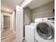 Laundry room featuring a white washer and dryer, a utility shelf and wood-look floors at 10124 Heathcliff St, Spring Hill, FL 34608