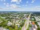 Vast aerial view of a suburban area featuring tree-lined streets, commercial buildings, and residential homes under a blue sky at 1071 Lexington Ct, Largo, FL 33771