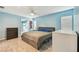 Spacious bedroom with blue walls, fan, wood-look floors, and access to closet and bathroom at 1071 Lexington Ct, Largo, FL 33771