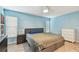 Spacious bedroom with blue walls, fan, wood-look floors, and two windows at 1071 Lexington Ct, Largo, FL 33771