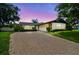Charming home featuring a brick driveway, lush landscaping, and a well-maintained lawn at 1071 Lexington Ct, Largo, FL 33771