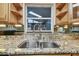 Close-up of the kitchen sink with a granite countertop and mirrored backsplash at 1071 Lexington Ct, Largo, FL 33771