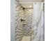 Shower with decorative tile surround, modern showerhead, shelf, and marble-patterned shower curtain at 1071 Lexington Ct, Largo, FL 33771