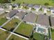 Aerial view featuring backyards with pools, patio furniture, and green spaces at 1098 Old Windsor Way, Spring Hill, FL 34609