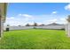 Expansive backyard with lush green grass and a white vinyl fence, offering privacy at 1098 Old Windsor Way, Spring Hill, FL 34609