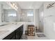 Bright bathroom featuring a walk-in shower, a double sink vanity, and neutral tile flooring at 1098 Old Windsor Way, Spring Hill, FL 34609