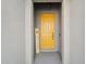 Welcoming yellow front door with covered entryway and neutral gray accents at 1098 Old Windsor Way, Spring Hill, FL 34609