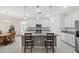 Well-lit kitchen with a gray island with seating, white cabinets, and modern appliances at 1098 Old Windsor Way, Spring Hill, FL 34609