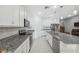 Modern kitchen with stainless steel appliances, granite countertops, and white cabinets at 1098 Old Windsor Way, Spring Hill, FL 34609
