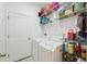 Functional laundry room equipped with a washer, dryer, and ample shelving for storage at 1098 Old Windsor Way, Spring Hill, FL 34609