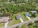 Aerial view features well-maintained homes with manicured lawns, complemented by lush greenery and a network of paved roads at 11034 Flock Ave, Weeki Wachee, FL 34613