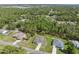 Aerial view features well-maintained homes with manicured lawns, complemented by lush greenery and a network of paved roads at 11034 Flock Ave, Weeki Wachee, FL 34613
