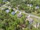 A beautiful aerial view shows several homes in a wooded neighborhood with well maintained lawns and paved roads at 11034 Flock Ave, Weeki Wachee, FL 34613