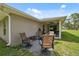Backyard patio features a seating area with comfortable chairs and a view of the covered back porch at 11034 Flock Ave, Weeki Wachee, FL 34613