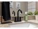 Close-up of granite countertop with black faucet, soap, and greenery showcasing modern design details at 11034 Flock Ave, Weeki Wachee, FL 34613