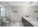 Bright bathroom featuring double sink vanity, granite counters, tiled floor and glass enclosed shower at 11034 Flock Ave, Weeki Wachee, FL 34613