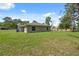 Exterior view of the home showcasing the spacious backyard and well-maintained lawn at 11034 Flock Ave, Weeki Wachee, FL 34613