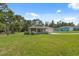 A single-story home sits on a spacious lot featuring lush green grass and mature trees offering shade and privacy at 11034 Flock Ave, Weeki Wachee, FL 34613