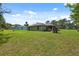 Exterior view of the home highlighting the expansive backyard and landscaping at 11034 Flock Ave, Weeki Wachee, FL 34613