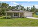 Charming single-story home with a well-manicured lawn, a covered front porch, and an attached two-car garage at 11034 Flock Ave, Weeki Wachee, FL 34613
