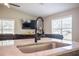 Close-up on kitchen sink and wraparound bar seating with clear view to the living room beyond at 11034 Flock Ave, Weeki Wachee, FL 34613
