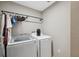 Bright laundry room featuring modern washer and dryer units with a hanging rod for convenience at 11034 Flock Ave, Weeki Wachee, FL 34613