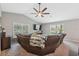 Bright living room features a vaulted ceiling, ceiling fan, and large windows at 11034 Flock Ave, Weeki Wachee, FL 34613