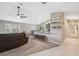 Open-concept living room features a vaulted ceiling, ceiling fan, and breakfast bar connecting to the kitchen at 11034 Flock Ave, Weeki Wachee, FL 34613