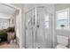 Bathroom with modern glass enclosed walk-in shower, updated fixtures, and a sunlit window at 11034 Flock Ave, Weeki Wachee, FL 34613