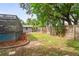 A fenced backyard with a pool, shed, and grass at 1131 Bentley Ave, Spring Hill, FL 34608