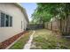 A fenced backyard featuring a concrete path and mulch bed at 1131 Bentley Ave, Spring Hill, FL 34608