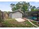 A backyard with a shed, concrete pad, pool, and grass at 1131 Bentley Ave, Spring Hill, FL 34608