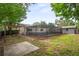 This backyard features a screened-in pool, a wooden pergola, and mature trees, creating a private outdoor oasis at 1131 Bentley Ave, Spring Hill, FL 34608