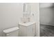 Bathroom featuring a white sink vanity and toilet with gray carpet in the hallway at 1131 Bentley Ave, Spring Hill, FL 34608