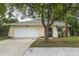Exterior view of this home, with a lush lawn, a well-maintained facade, and mature trees enhancing its appeal at 1131 Bentley Ave, Spring Hill, FL 34608