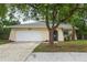Charming single-story home with a well-maintained lawn, mature trees, and a two-car garage at 1131 Bentley Ave, Spring Hill, FL 34608