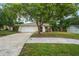 Well-kept single-story home with mature trees, manicured lawn, and a two-car garage enhancing curb appeal at 1131 Bentley Ave, Spring Hill, FL 34608