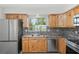 Bright kitchen with wooden cabinets, stainless steel fridge and appliances, and tile backsplash at 1131 Bentley Ave, Spring Hill, FL 34608