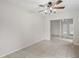 An interior view of a living room featuring neutral walls, tile flooring, a ceiling fan, and sliding doors at 1131 Bentley Ave, Spring Hill, FL 34608