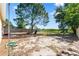 A spacious backyard with a mature tree, lush greenery, and a partial fence at 11524 Meadow Dr, Port Richey, FL 34668