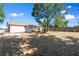 Expansive backyard featuring a mature tree, partial fencing, and ample space for outdoor activities at 11524 Meadow Dr, Port Richey, FL 34668