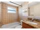 Cozy bathroom featuring a shower-tub combo, granite vanity, and tiled walls at 11524 Meadow Dr, Port Richey, FL 34668