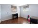 A well-lit bedroom with desk, laminate wood flooring, and soft gray window treatments at 11524 Meadow Dr, Port Richey, FL 34668