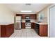 Well-appointed kitchen with stainless steel appliances, dark wood cabinets, and tile backsplash at 11524 Meadow Dr, Port Richey, FL 34668